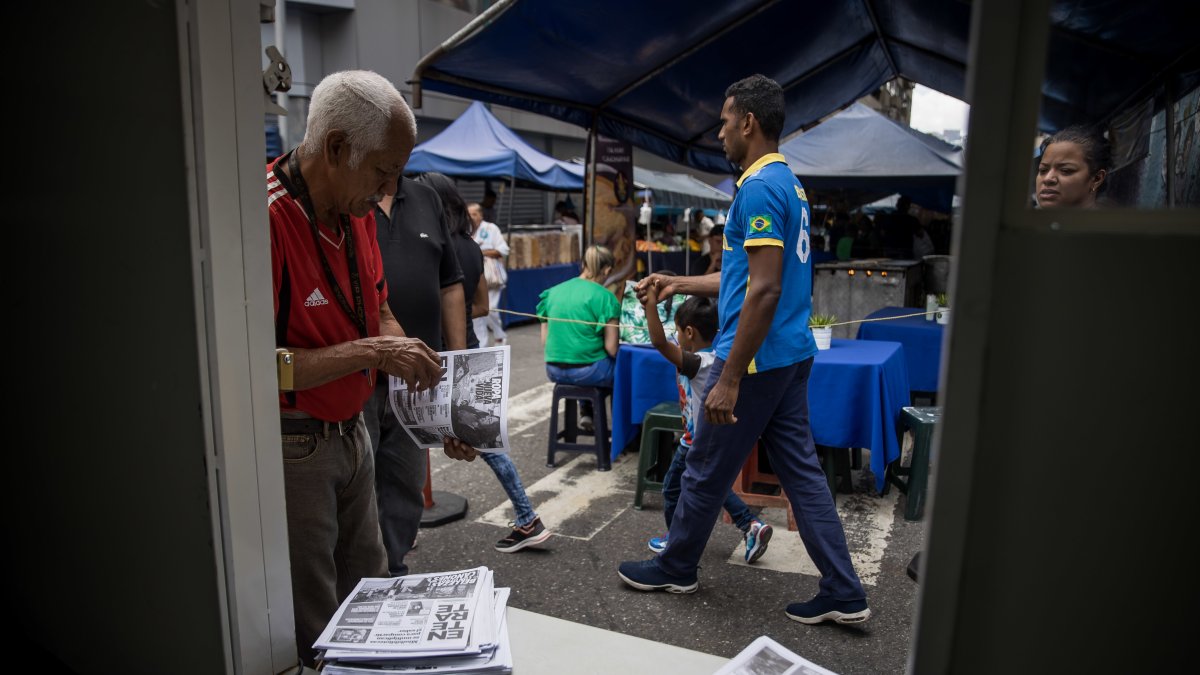 Caracas.  Un hombre toma un periódico del camión de información.
