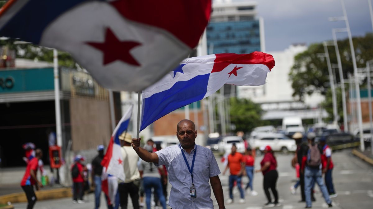 Un hombre agita una bandera nacional como protesta en rechazo al contrato entre el Estado y Minera Panamá, subsidiaria de la canadiense First Quantum Minerals, hoy, en Ciudad de Panamá (Panamá).