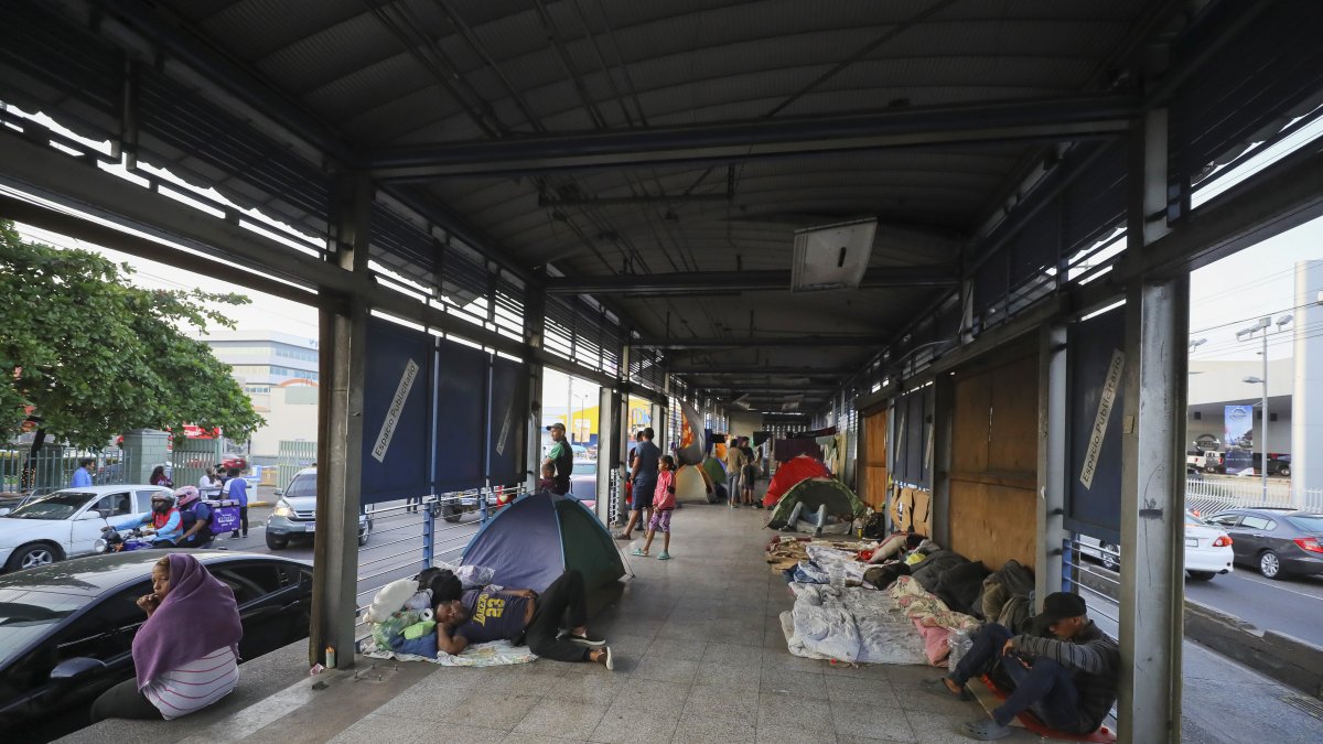 Migrantes permanecen en tiendas de campaña en una estación de transporte público fuera de servicio, el 21 de noviembre de 2023, en Tegucigalpa (Honduras).