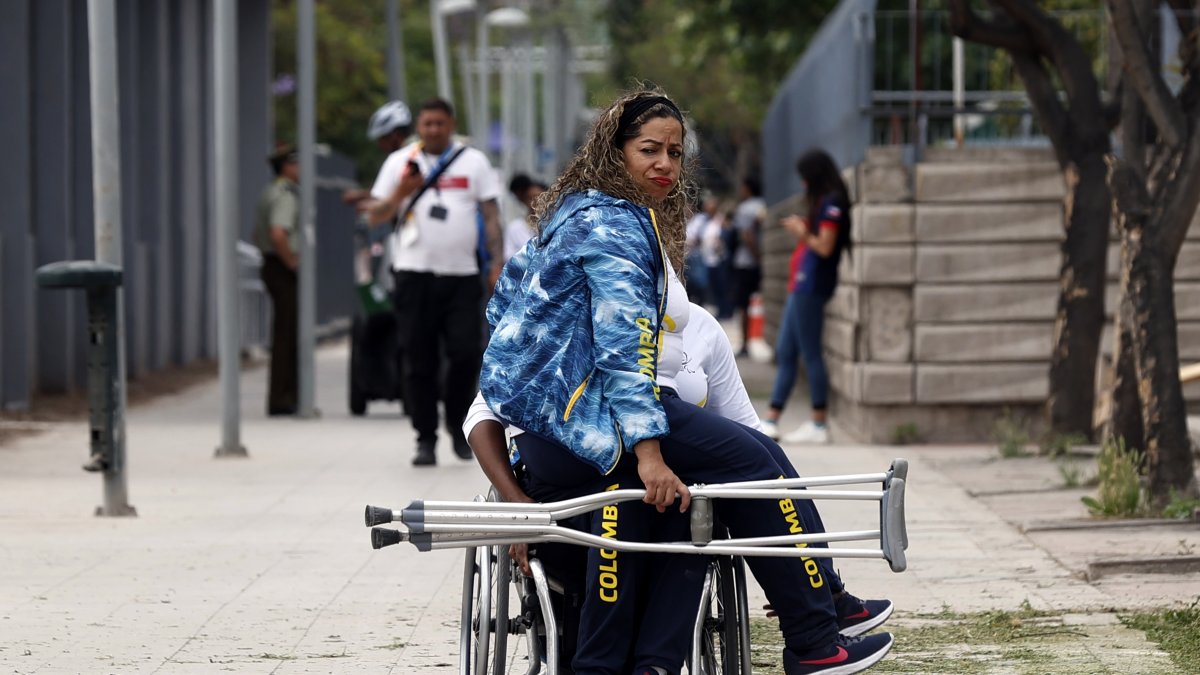Una deportista de la selección de Colombia se transporta en las piernas de uno de sus compañeros de equipo. Eso incluso dentro de la misma villa parapanamericana.