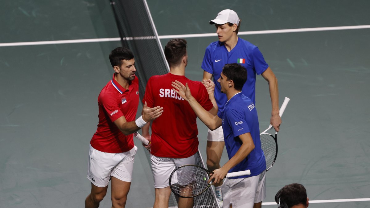 Los jugadores de la selección de Italia de tenis Jannik Sinner y Lorenzo Sonego (d) tras el saludo con los jugadores de Serbia Novak Djokovic y Miomir Kecmanovic.