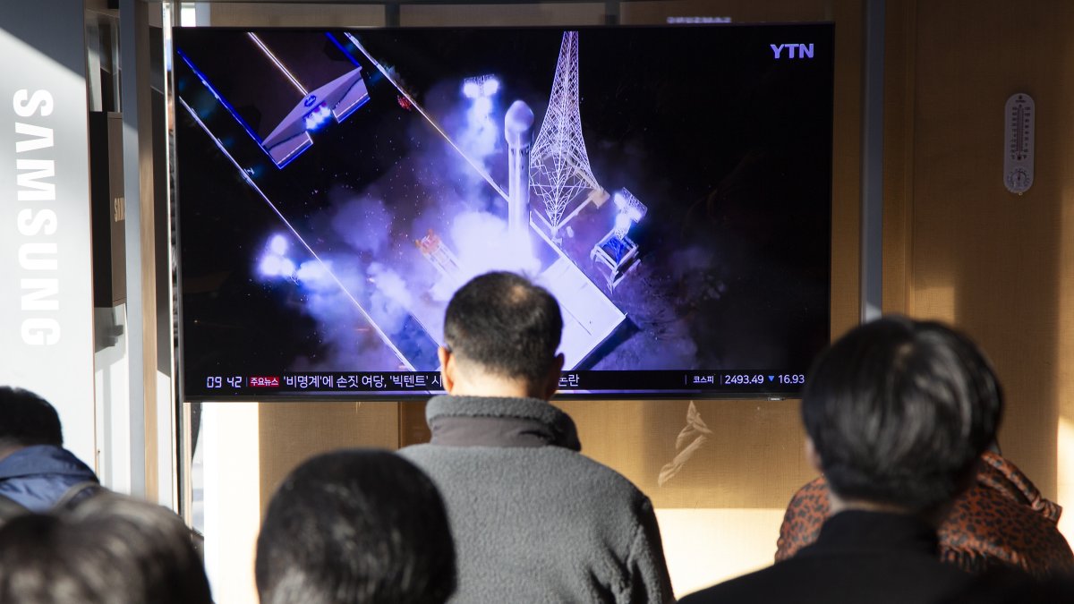 Seúl. Personas siguen las noticias sobre el satélite espía.