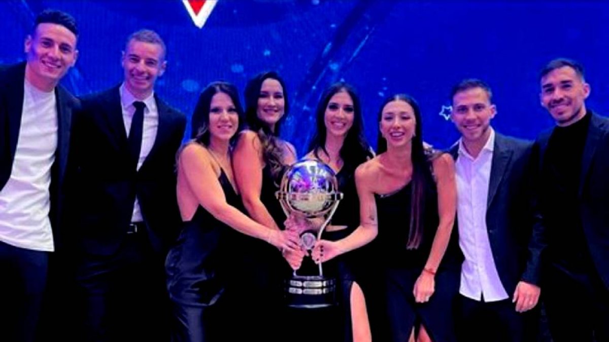 Los argentinos Mauricio Martínez (i), Adrián Gabbarini, Ezequiel Piovi y Lisandro Alzugaray (d) posaron con sus esposas y el trofeo de la Copa Sudamericana.