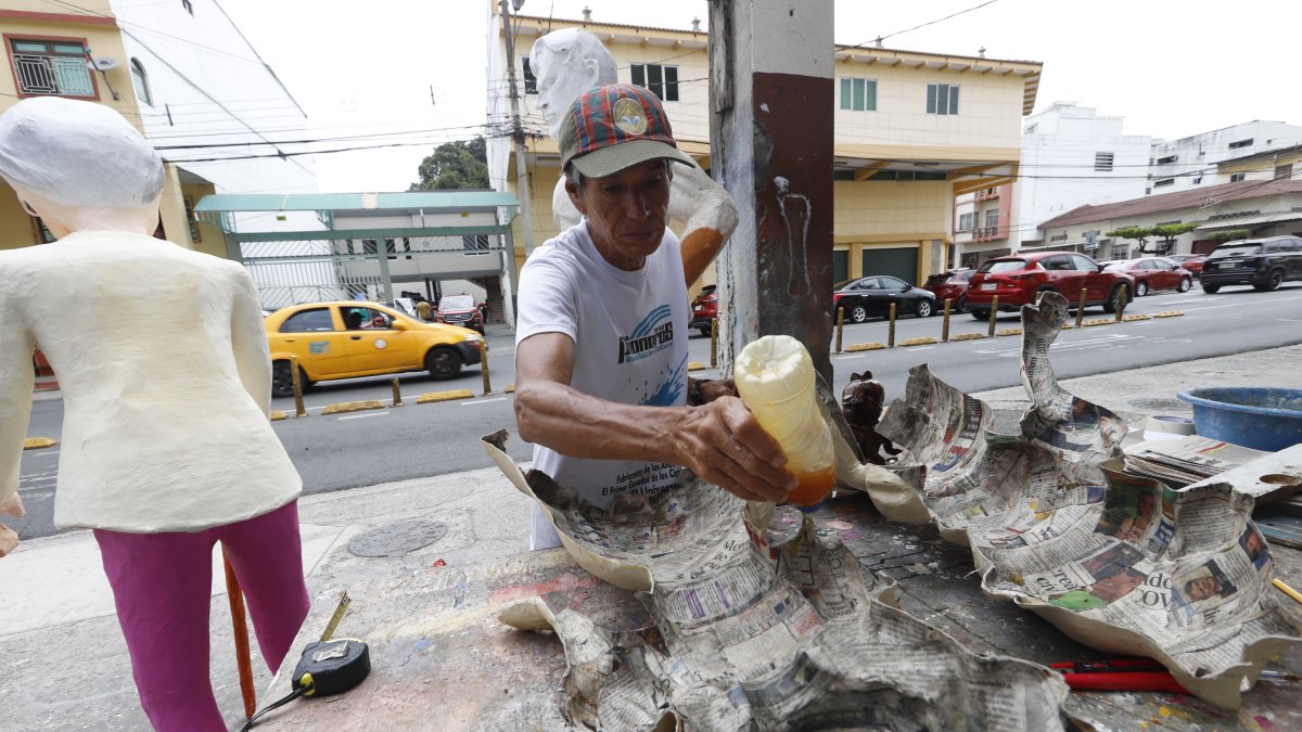 Monigoteros. Un artesano mientras moldea una figura.