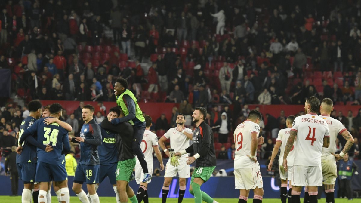 Los jugadores del PSV (i) celebran la victoria ante los del Sevilla, al término del partido de la fase de grupos de la Liga de Campeones.