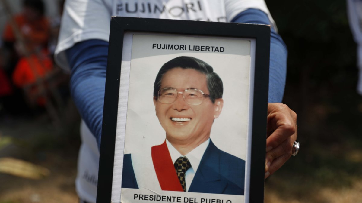 Fotografía de archivo en la que se registró a un seguidor del expresidente peruano Alberto Fujimori al sostener en sus manos una foto del exmandatario, en Lima (Perú).