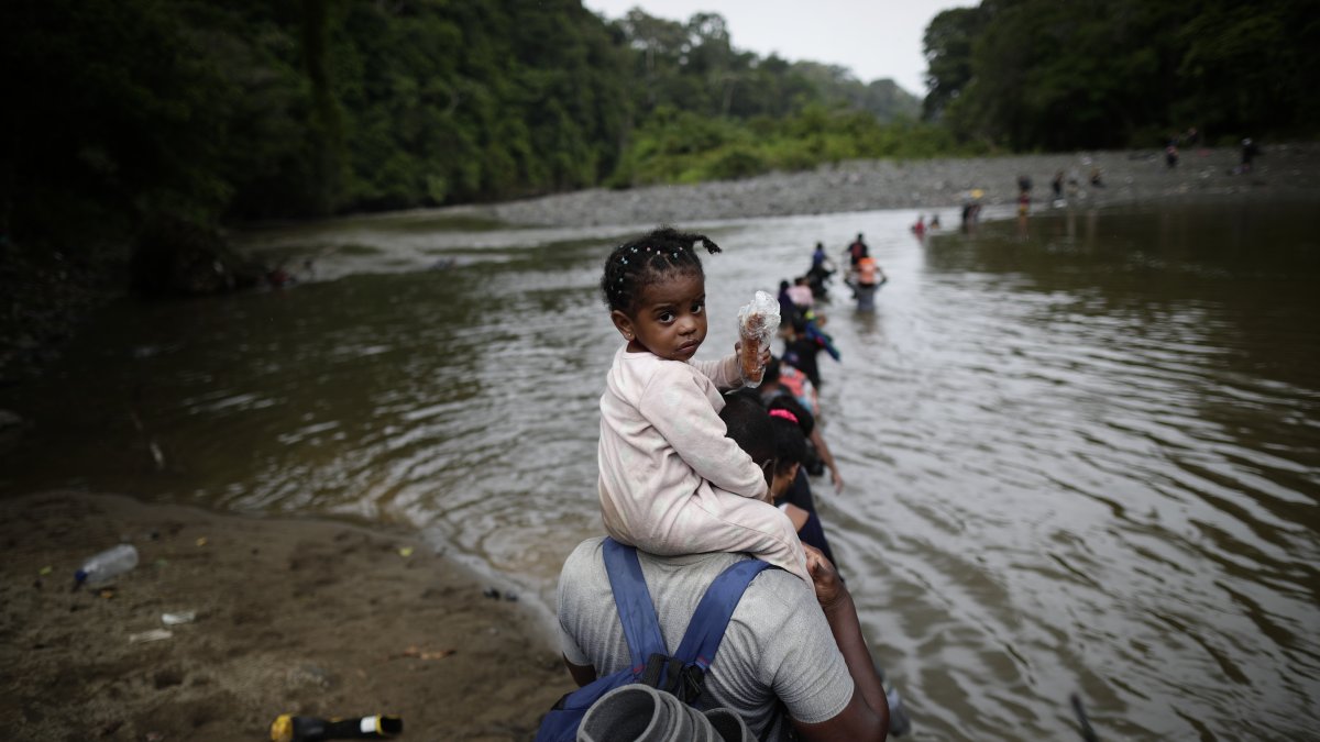 Migrantes cruzan el río Turquesa, en Darién (Panamá)