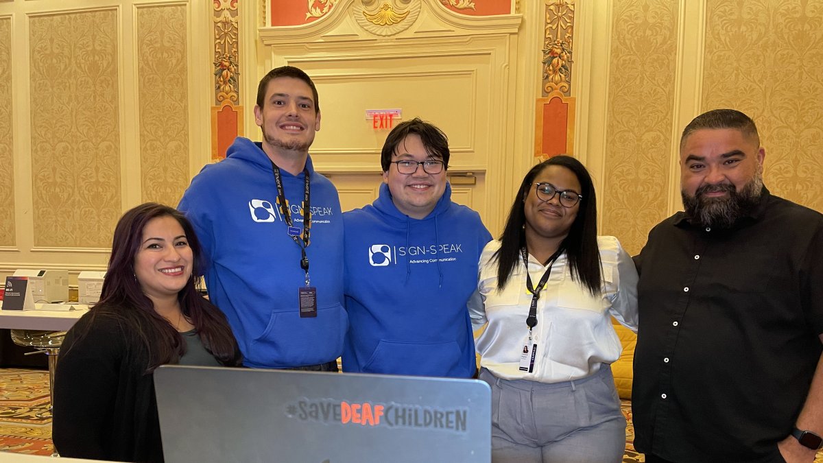 Los cofundadores de la aplicación Sign-Speak, Yamillet Payano (2d), y Nicholas Wilkins (c), posan junto a los intérpretes del Departamento de Personas con Discapacidad de Amazon.