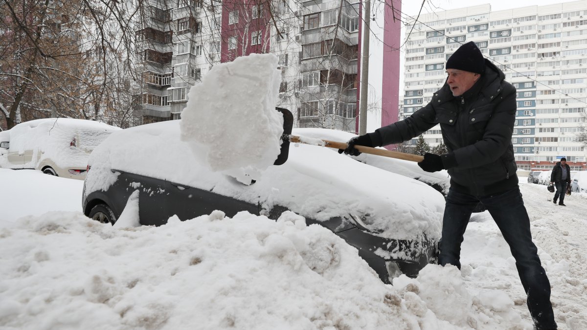 Un hombre palea nieve después de una Nevada en Moscú (Rusia), este 4 de diciembre de 2023.
