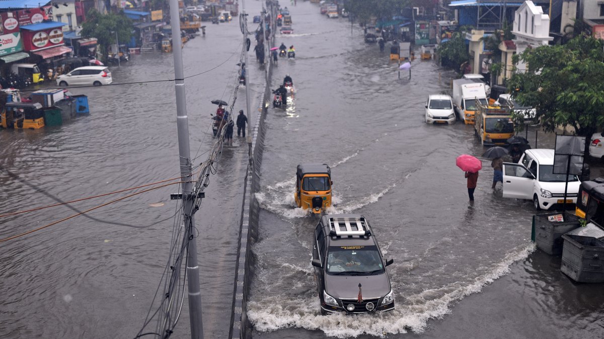 Las personas pasan por una carretera inundada durante las fuertes lluvias, ya que se espera que el ciclón Michaug, en Chennai (India), el 4 de diciembre de 2023.