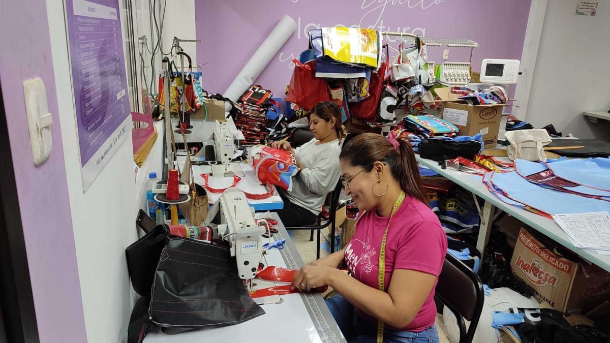 Labor.- Mujeres que hacen carteras y mochilas con lonas publicitarias.