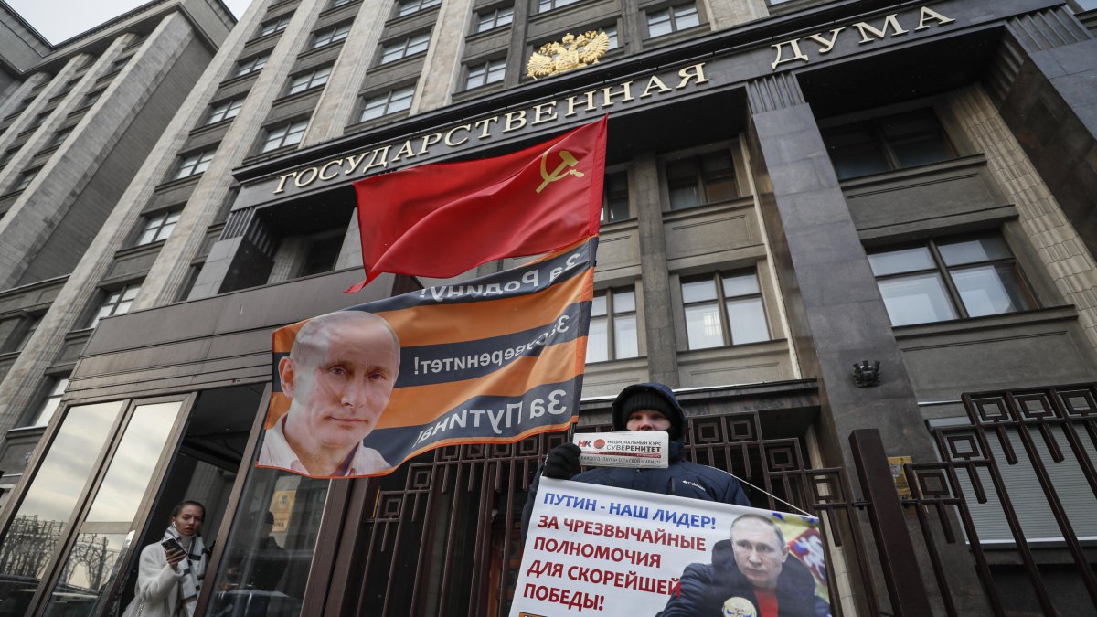 Moscú. Un hombre lleva una pancarta (“Putin es nuestro líder”), frente a la sede de la Federación de Rusia.