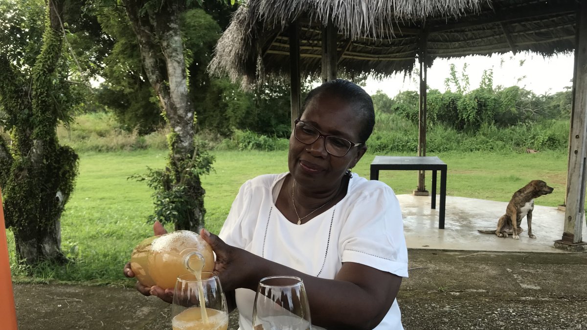 Nidia Cortez sirve en una copa el guarapo y explica cómo beberlo.