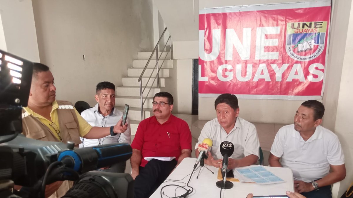 Dirigentes de la Unión Nacional de Educadores, entre ellos Jorge Escala (de rojo) e Hilario Beltrán (hablando), denunciaron la mora patronal de 23 distritos de Guayas.
