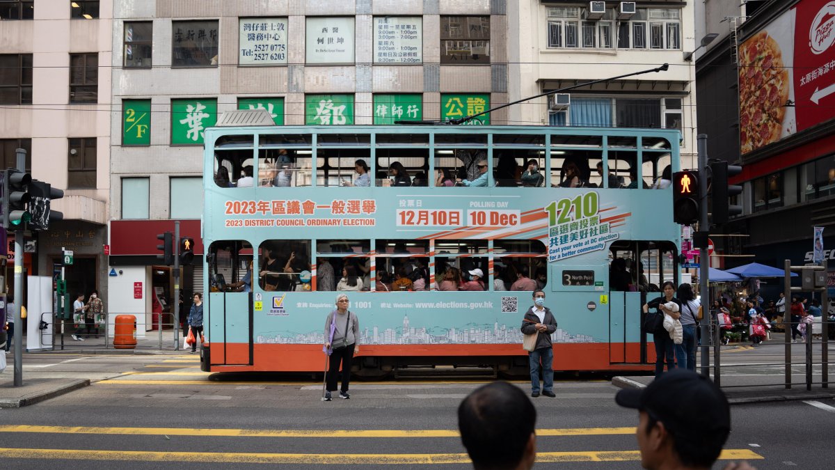 Un tranvía que muestra el anuncio de las elecciones ordinarias del Consejo de Distrito pasa por Hong Kong, China, el 10 de diciembre de 2023.
