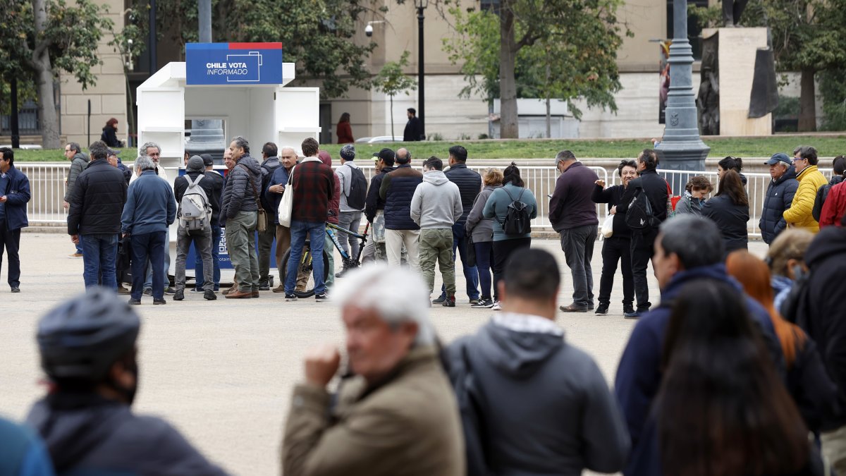 Personas hacen fila para obtener un ejemplar de la propuesta constitucional, el 17 de noviembre 2023, en Santiago (Chile).
