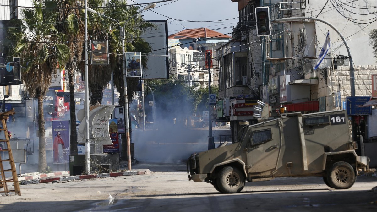 Jenin. Un vehículo militar israelí en medio de los gases lacrimógenos cerca a un campo de refugiados.