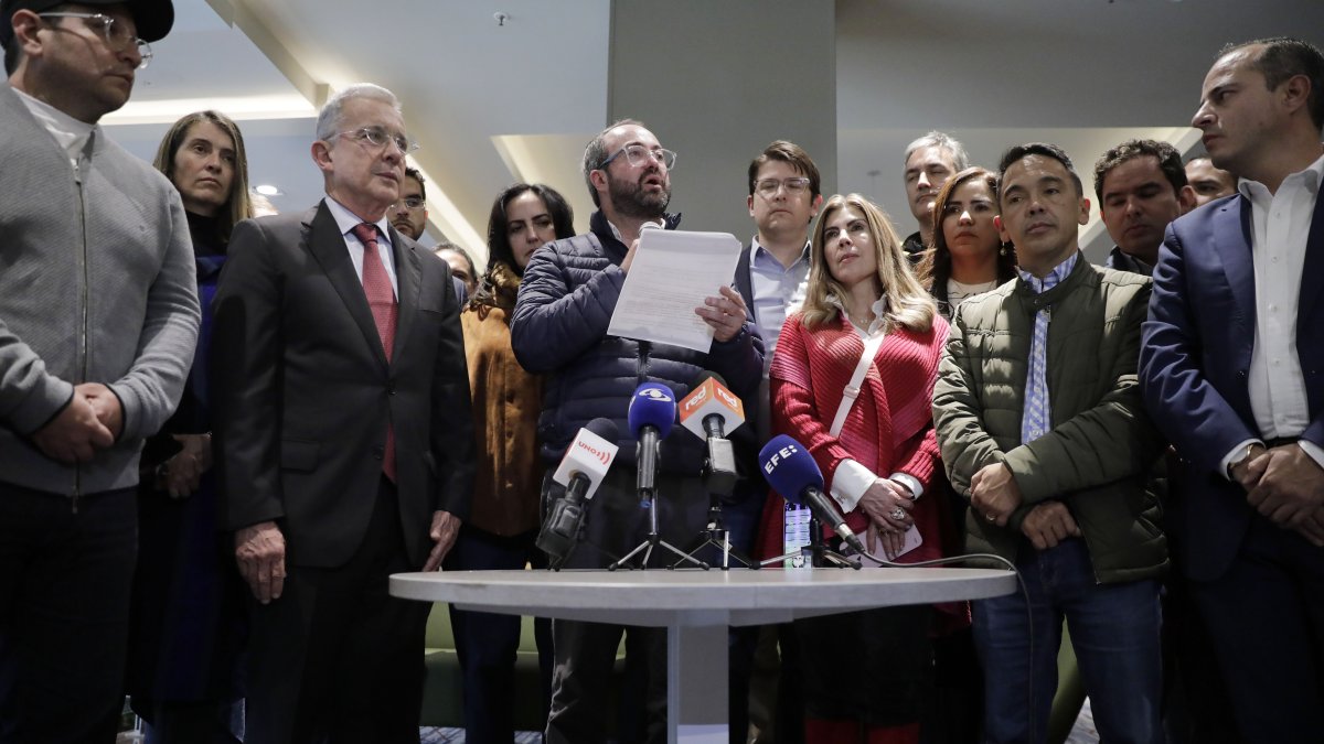 El senador colombiano Ciro Ramírez (c), al leer un comunicado, junto al expresidente de Colombia Álvaro Uribe Vélez, en julio de 2022.