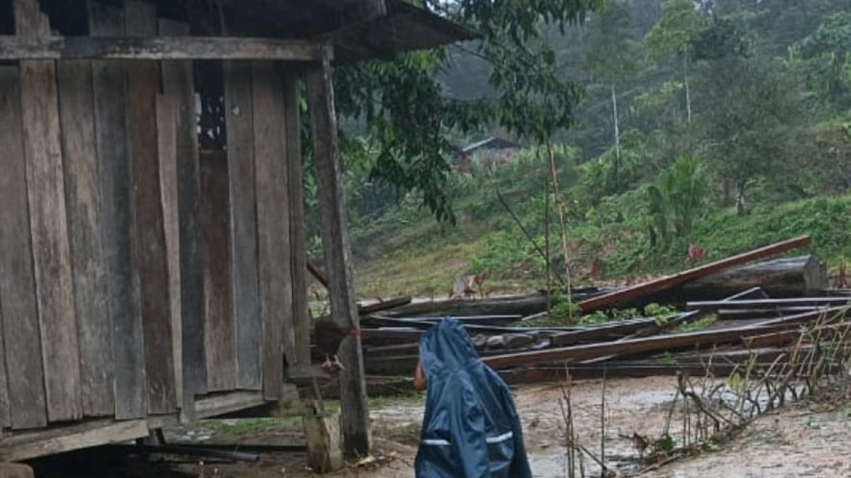 Un menor de edad se cubre de las intensas lluvias.