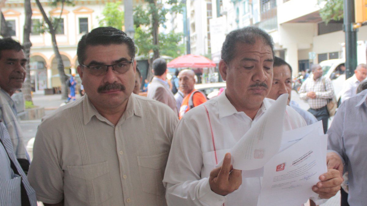 Los dirigentes Jorge Escala y Alonso López, de Unidad Popular, muestran la denuncia presentada en la Fiscalía.