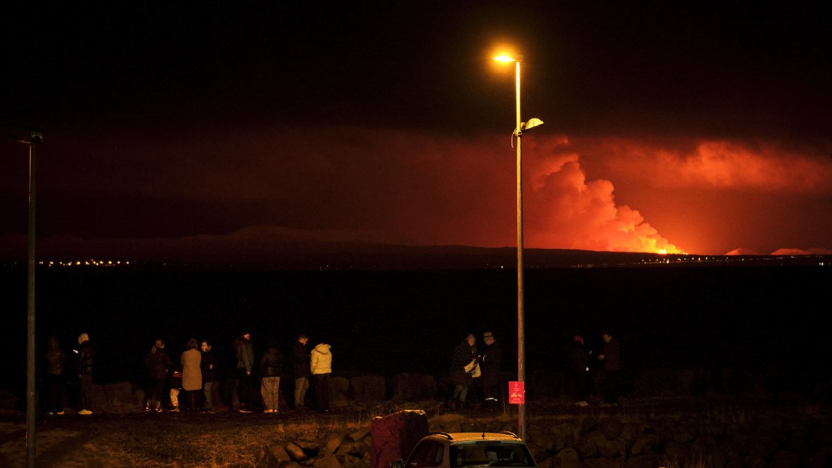 Grindavík (Islandia). Un grupo de personas observa a lo lejos la erupción.