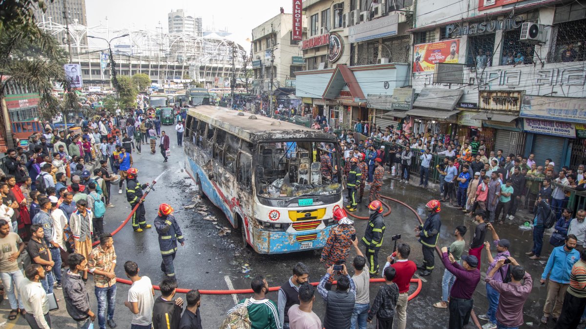 Una gran cantidad de personas rodean el autobús que se incendió ayer en la ciudad de Dacca, este 19 de diciembre de 2023.
