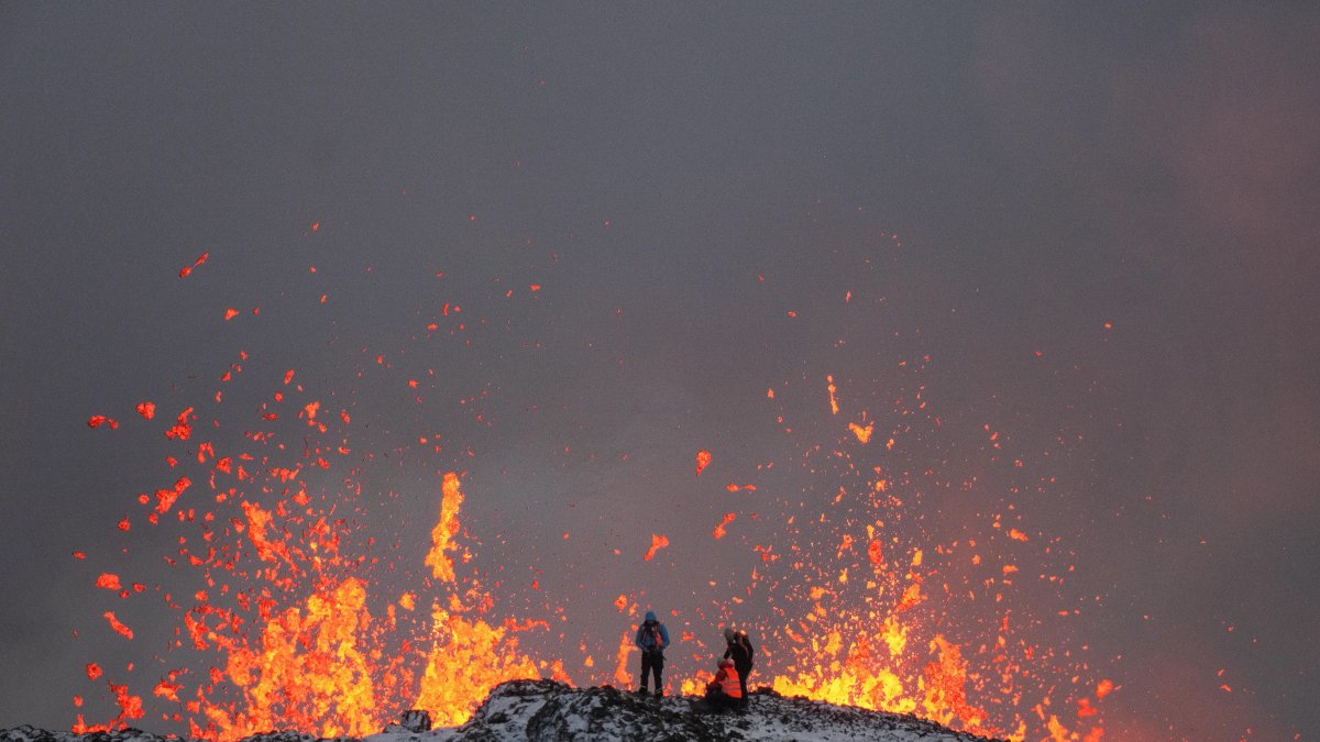 Un equipo de científicos trabaja, en la cresta de una fisura volcánica mientras sale lava durante una erupción volcánica, cerca de la ciudad de Grindavik, en la península de Reykjanes (Islandia).