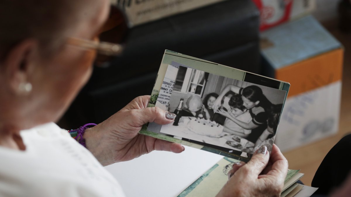 Eugenia Moraga observa una fotografía de ella junto a su hijo, Rodrigo Palma, durante una entrevista con EFE el 13 de diciembre 2023, en Santiago (Chile)