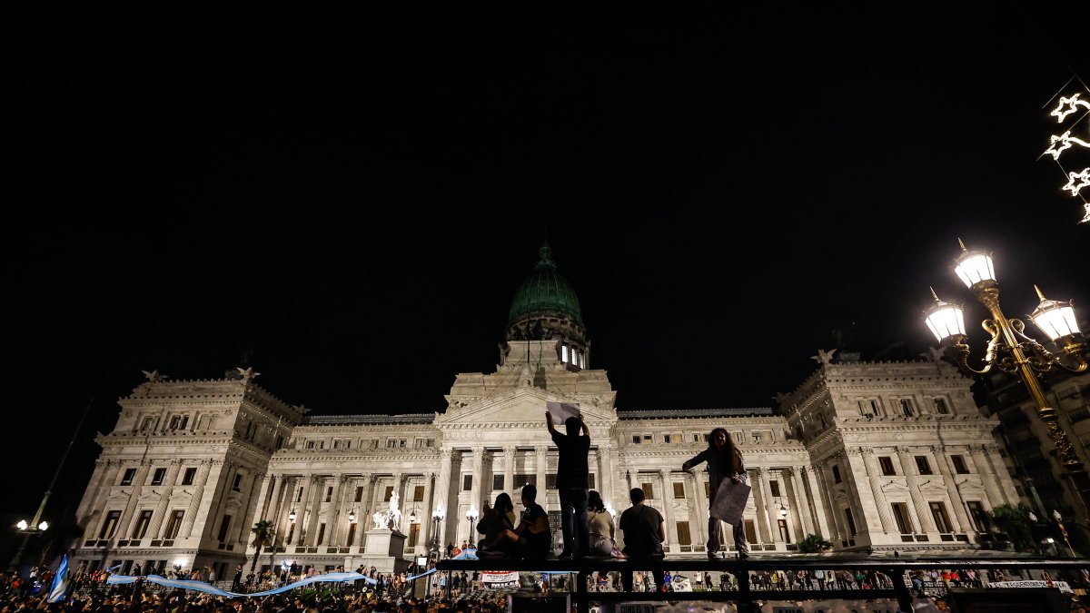 Docenas de personas participan en una manifestación contra las medidas anunciadas por el presidente Javier Milei, frente al Congreso de la Nación en Buenos Aires (Argentina).