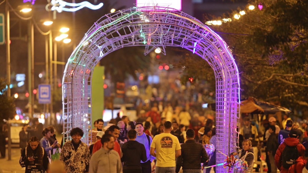 Personas recorren decoraciones navideñas, el 19 de diciembre del 2023, en Quito.