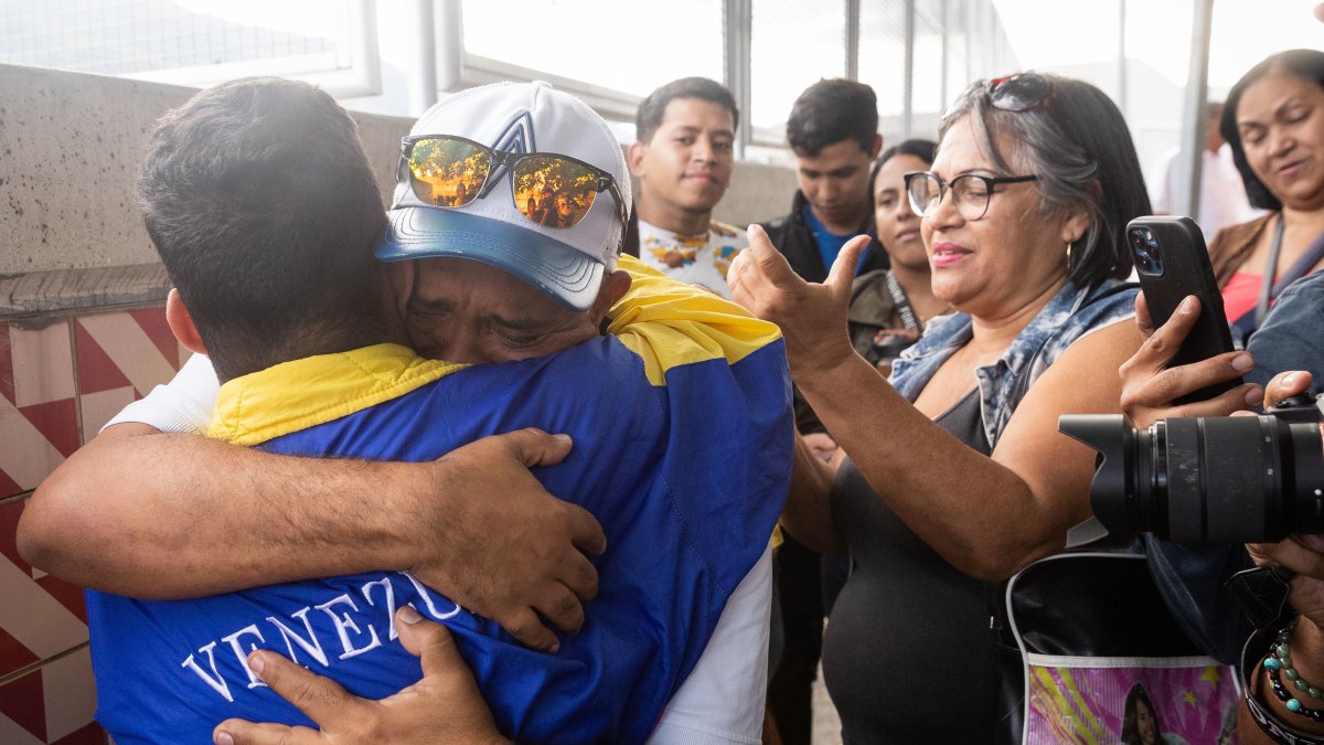 John Álvarez (2i) abraza a su hijo, el estudiante universitario John Álvarez (i), luego de que este saliera en libertad de un centro de reclusión de la Policía Nacional Bolivariana (PNB) en Caracas.