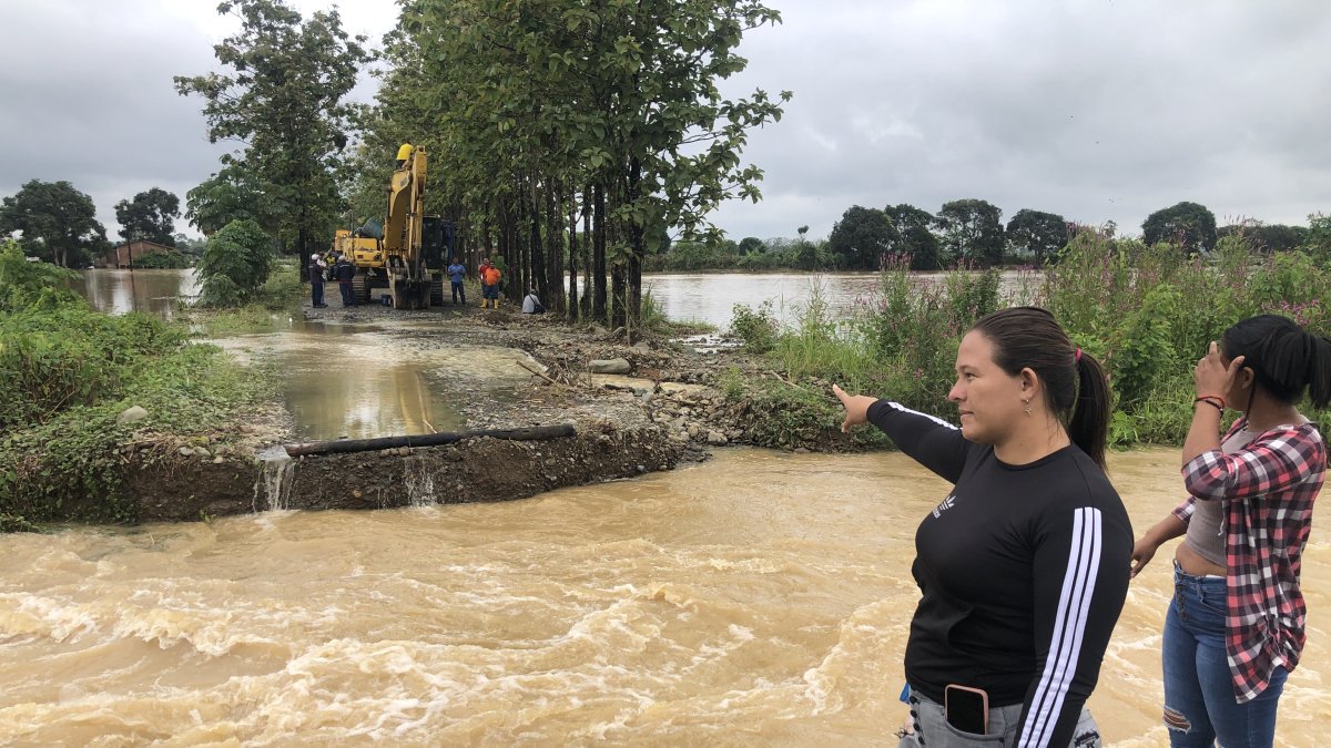 Moradores observan el lugar donde la creciente del río Las Juntas se llevó un tramo de la carretera.