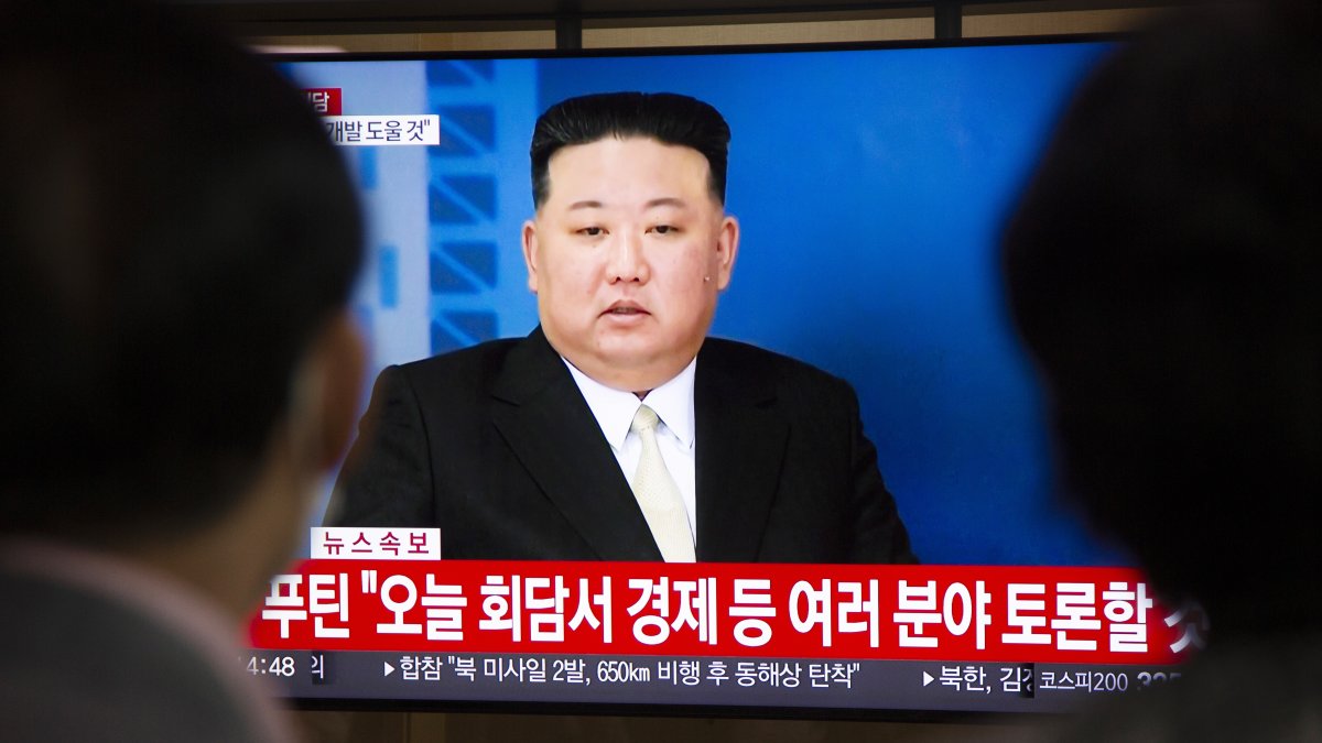 Dos personas viendo en televisión al líder norcoreano Kim Jong-un.