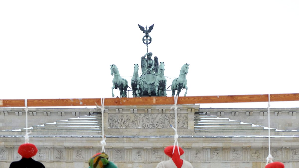 Imagen de archivo de una protesta con la ejecución simbólica de cuatro muñecos encima de una bandera iraní frente a la Puerta de Brandeburgo, en Berlín.