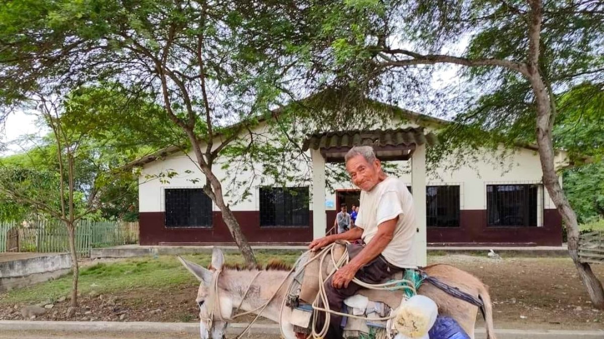 Cadeate. Lugareño se traslada en su asno, en una calle de esta comuna.
