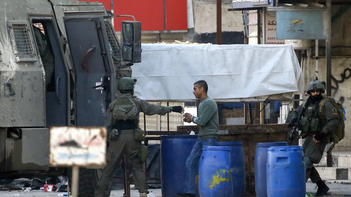 Soldados israelíes detienen a un palestino durante una incursión del ejército israelí en el campo de refugiados de Askar, en las afueras de la ciudad cisjordana de Naplusa, el 31 de diciembre de 2023.
