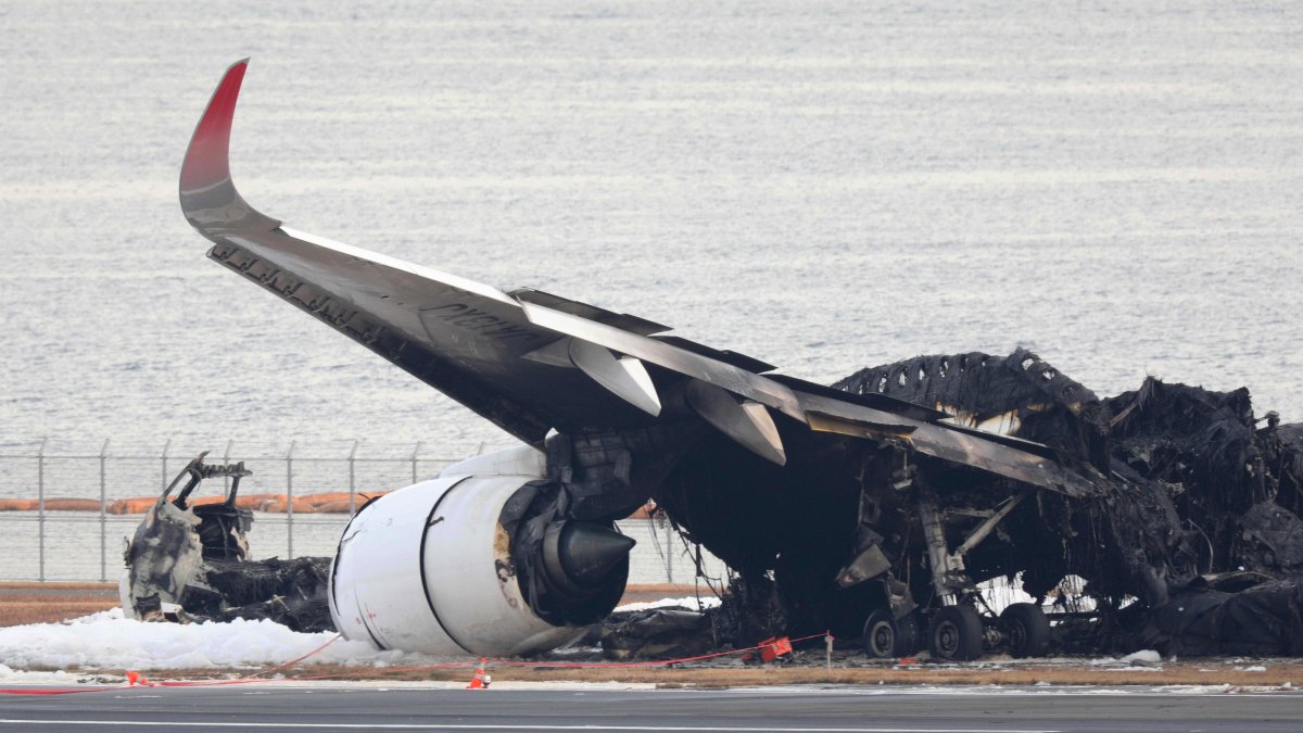 Tokio. Investigadores aeronáuticos inspeccionan los restos del avión incendiado en el aeropuerto de Haneda.