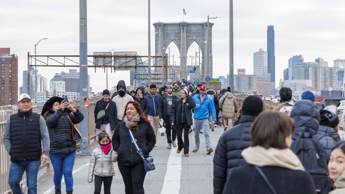 Varias personas caminando por el puente de Brooklyn sin vendedores a la vista en Nueva York.