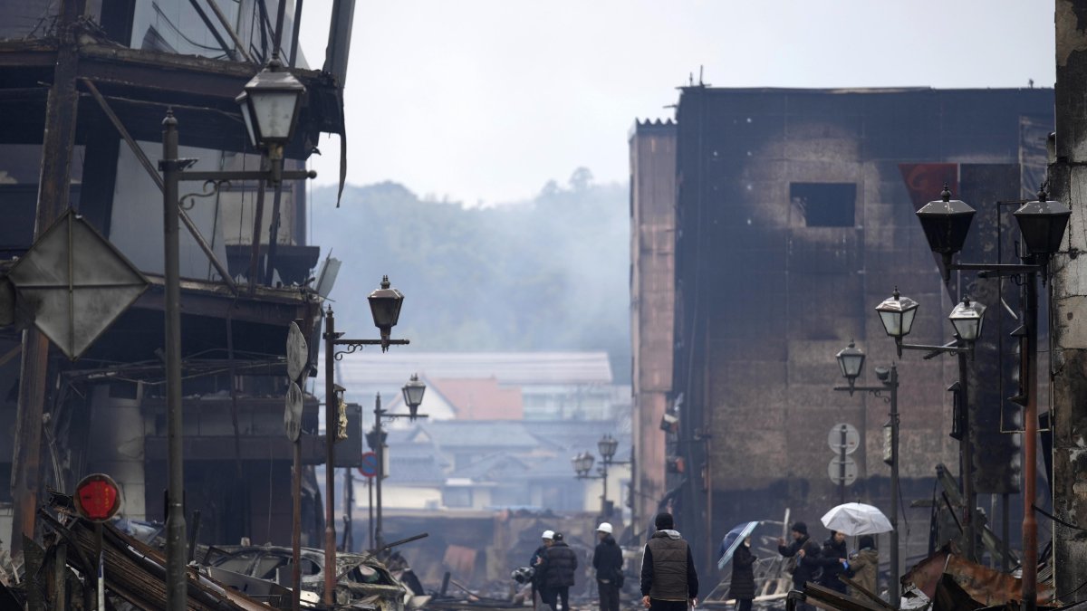 Wajima. Dos personas miran estructuras dañadas por el terremoto.