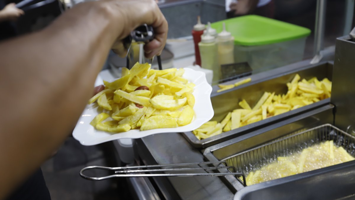 Local. El ayudante en uno de los locales, especializado en la salchipapa y papipollo, fríe la papa.