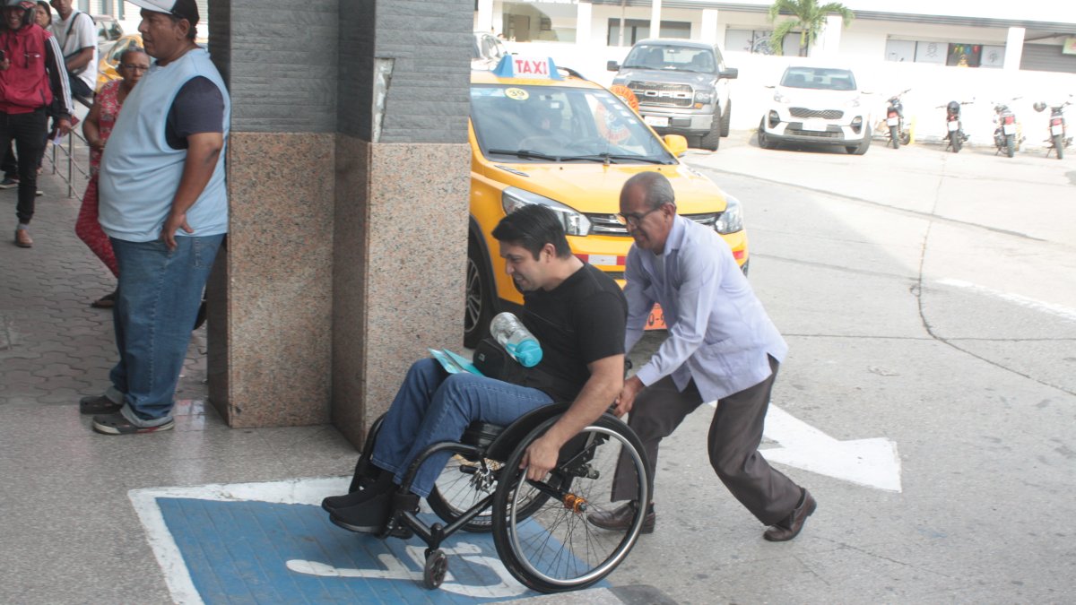 Discapacidad. Luis Morán necesita apoyo a diario para subir la rampa que está ubicada en el ingreso a la Unidad Judicial Albán Borja, en el norte de Guayaquil, donde labora.