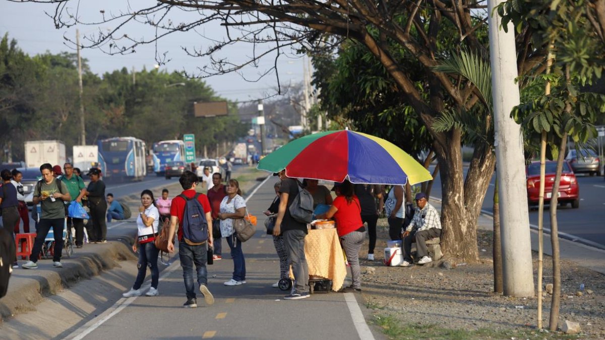 La presencia de comerciantes informales y compradores genera obstrucciones en la ciclorruta de la vía a la costa.