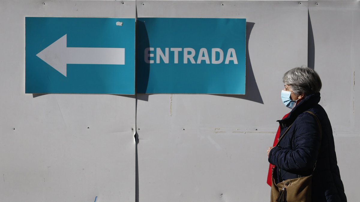 Una mujer camina cerca de un centro de salud en Madrid este 8 de enero de 2024, día en el que el Ministerio de Sanidad ha pedido que implanten el uso obligatorio de mascarilla en centros sanitarios.