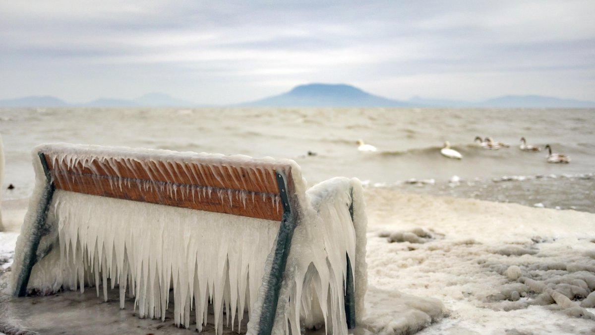 Balatonfenyves. El hielo cubre banco a orillas de lago en Hungría.
