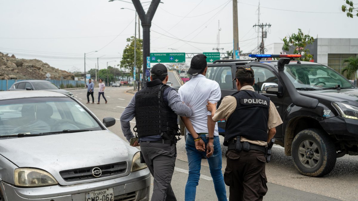 Policías detienen hoy a un presunto delincuente a pocas cuadras de la sede del canal de televisión TC, donde encapuchados armados ingresaron y sometieron a su personal durante una transmisión en vivo, en Guayaquil (Ecuador).