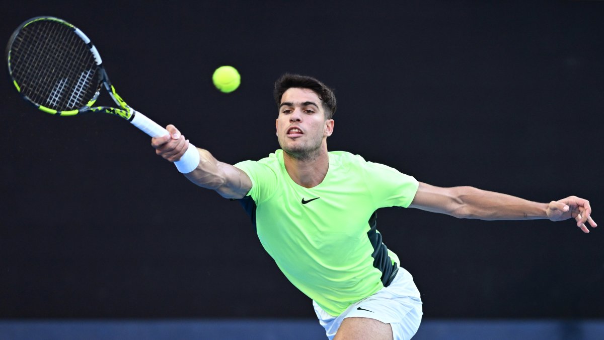 Carlos Alcaraz, de España, en acción contra Alex de Miñaur de Australia durante un partido de tenis benéfico antes del Abierto de Australia.