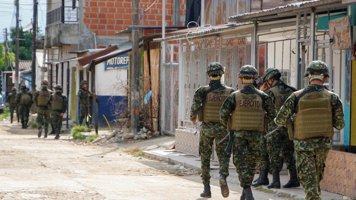 Soldados del Ejercito colombiano recorren una calle de una población rural.