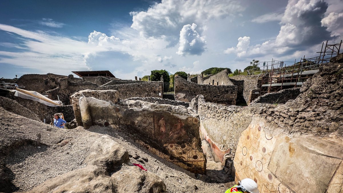Un arqueólogo trabaja en un mural descubierto durante los trabajos de excavación en el sitio arqueológico de Pompeya, en Pompeya, cerca de Nápoles, Italia.