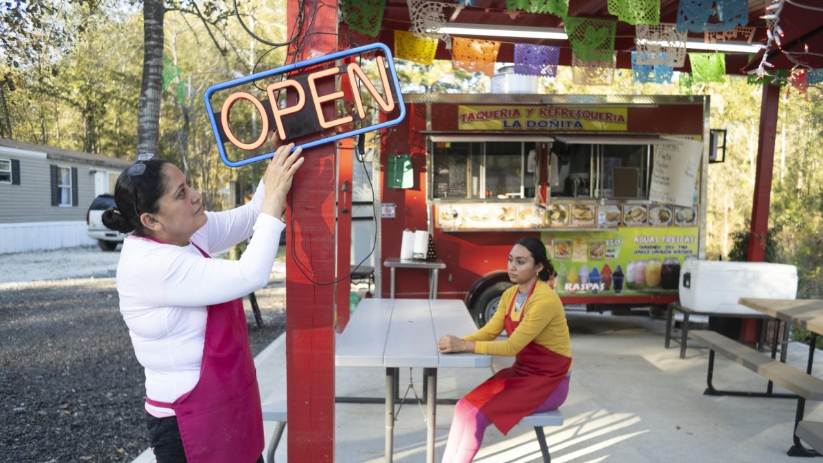 Yelva Cortés (i) y Yolanda Romero (d), ambas naturales de Michoacán (México), esperan clientes en el restaurante móvil donde trabajan en el condado Liberty.