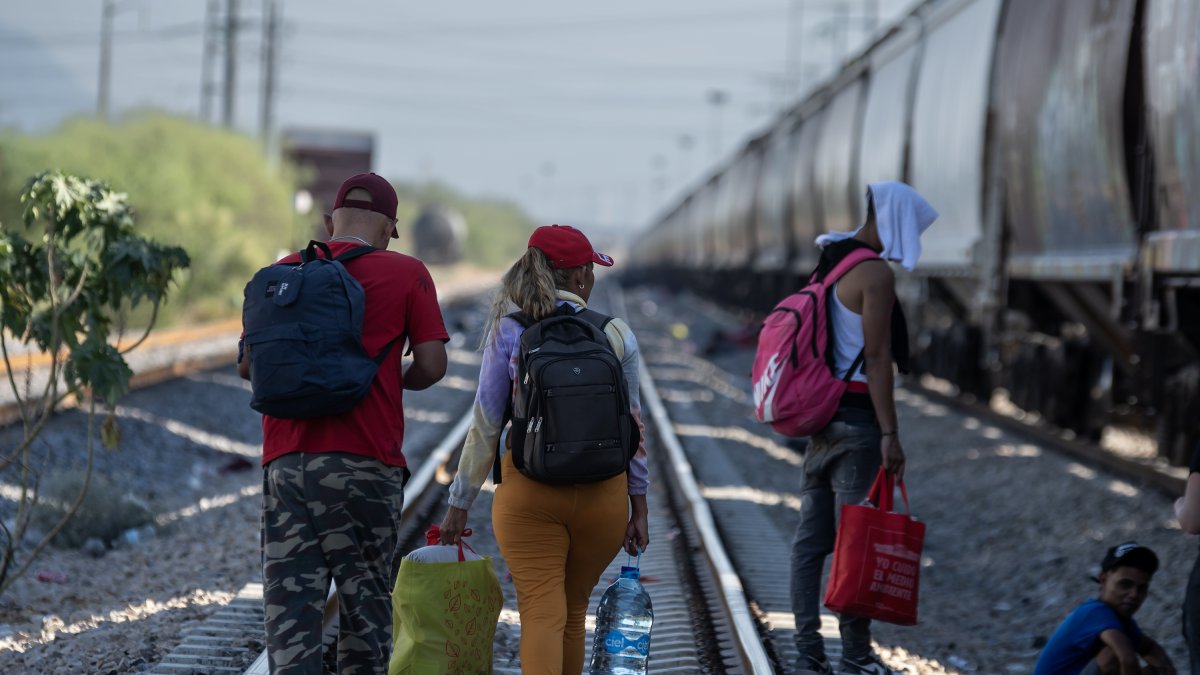 Un grupo de migrantes caminan por las vías del tren en algún lugar de México.